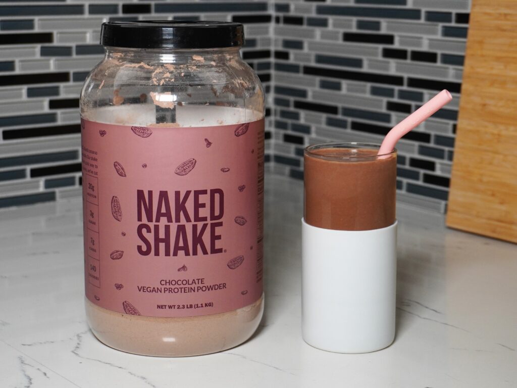 Vegan protein shake from Naked Nutrition alongside a tub of vegan protein powder